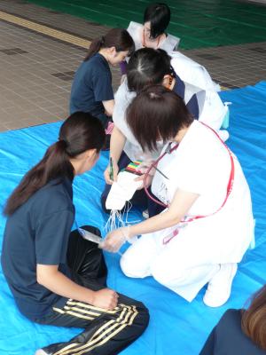 傷病者(松山赤十字看護専門学校生)のトリアージをする看護師